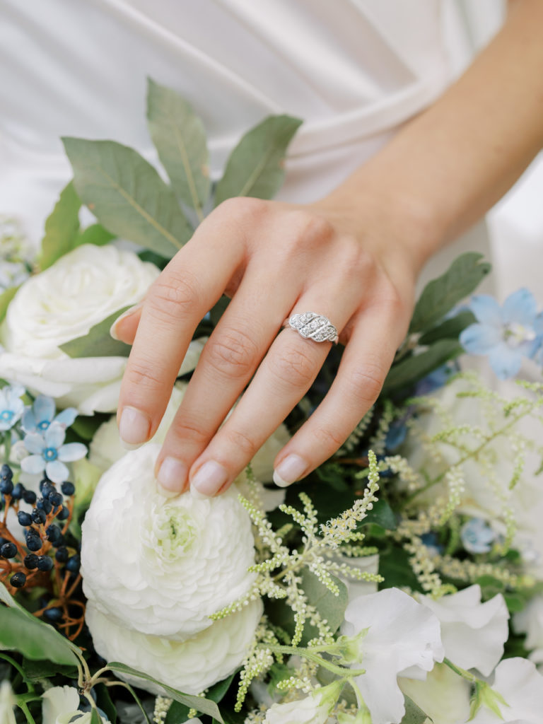 closeup of bride's ring on hand with bridal bouquet