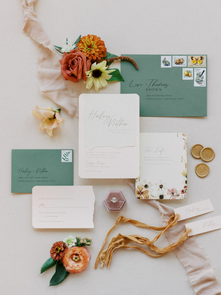 invitation suite flat lay with green and rust colors