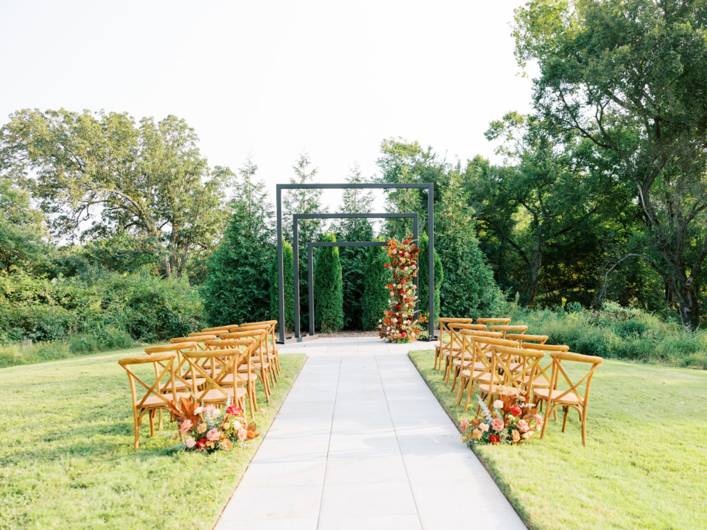 picture of fall ceremony setup with wood chairs and fall florals at Osage House